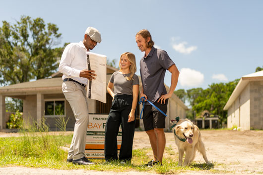Contractor showing couple walking dog house plans